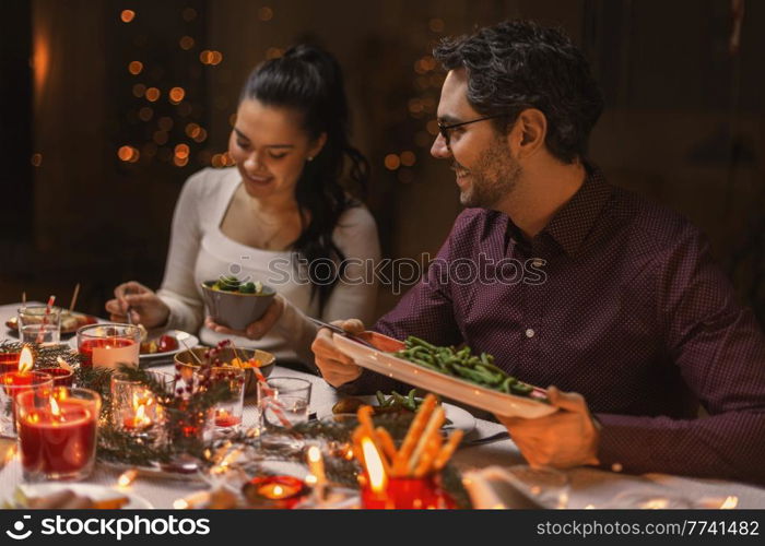 holidays, party and celebration concept - happy friends having christmas dinner at home. happy friends having christmas dinner at home