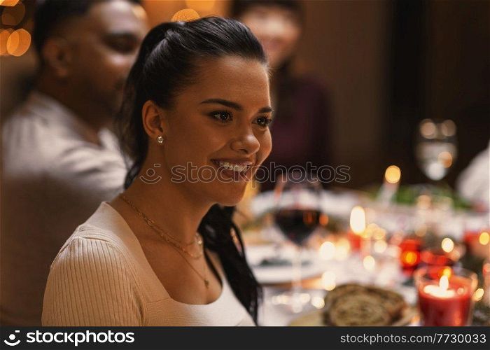 holidays, party and celebration concept - happy woman having christmas dinner with friends at home. happy woman having christmas dinner with friends