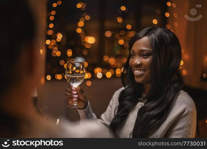 holidays, party and celebration concept - happy woman with glass of wine having christmas dinner at home. happy woman with glass of wine at christmas party