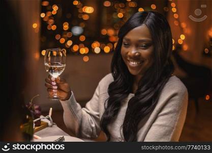 holidays, party and celebration concept - happy woman with glass of wine having christmas dinner at home. happy woman with glass of wine at christmas party