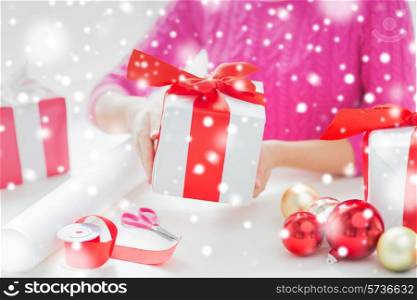holidays, people and celebration concept - close up of woman decorating christmas presents
