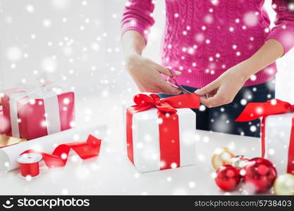 holidays, people and celebration concept - close up of woman decorating christmas presents