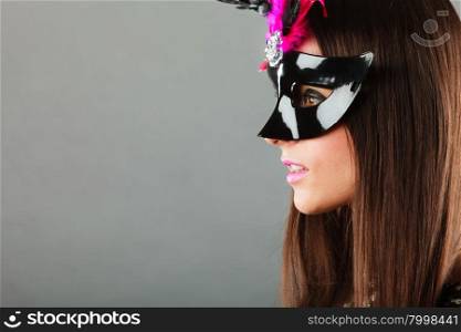 Holidays, people and celebration concept. Closeup woman face profile with carnival venetian mask on gray background.