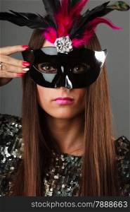 Holidays, people and celebration concept. Closeup woman face with carnival venetian mask sequin evening dress on gray background.