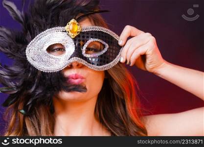 Holidays, people and celebration concept. Closeup woman face with carnival venetian mask on dark background.. Closeup woman face with carnival mask on dark