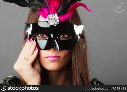 Holidays, people and celebration concept. Closeup woman face with carnival venetian mask on gray background.