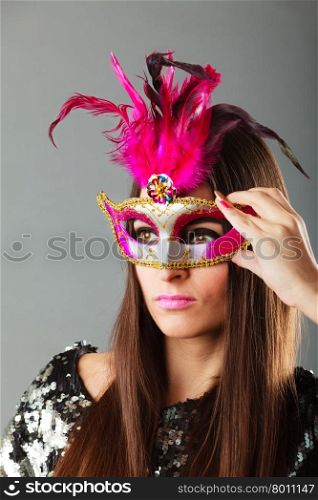 Holidays, people and celebration concept. Closeup woman face with carnival venetian mask on gray background.