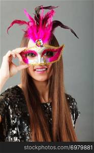 Holidays, people and celebration concept. woman face with carnival venetian mask sequin evening dress on gray background.