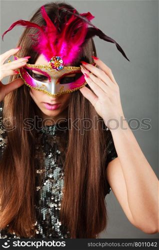 Holidays, people and celebration concept. woman face with carnival venetian mask sequin evening dress on gray background.