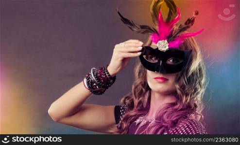 Holidays, people and celebration concept. Woman with carnival venetian mask on colorful background.