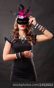 Holidays, people and celebration concept. Woman with carnival venetian mask on dark background.