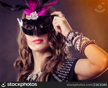 Holidays, people and celebration concept. Woman with carnival venetian mask on dark background.