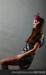 Holidays, people and celebration concept. woman with carnival venetian mask sequin evening dress on gray background.