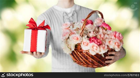holidays, people, feelings and greetings concept - close up of man holding basket full of flowers and gift box over green background