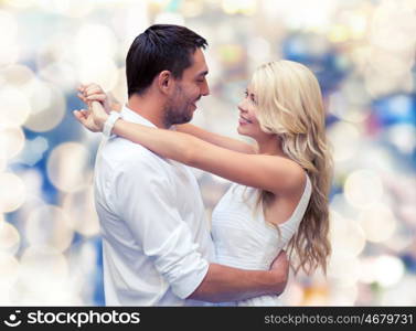 holidays, people, love and dating concept - happy couple hugging over lights background