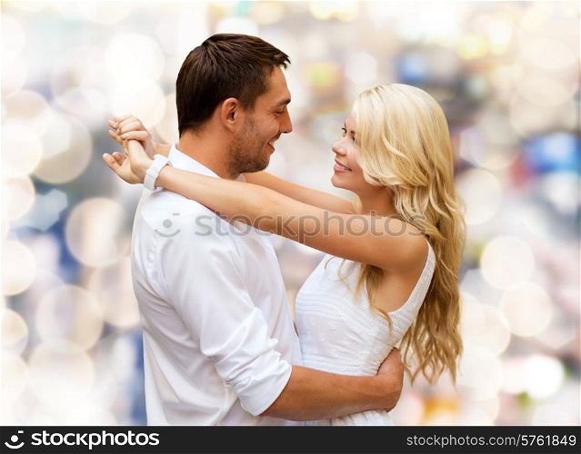 holidays, people, love and dating concept - happy couple hugging over lights background