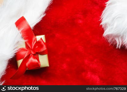 Holidays, present, christmas concept. Small golden box with gift tied decorative bow on red background