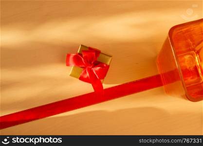 Holidays, present concept. Small golden box with gift tied decorative bow and empty vase