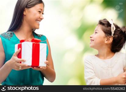 holidays, presents, christmas, family, child and x-mas concept - happy mother and child girl with gift box