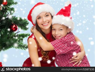 holidays, presents, christmas, x-mas concept - happy mother and child boy in santa helper hats