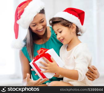 holidays, presents, christmas, x-mas concept - happy mother and child girl in santa helper hats with gift box