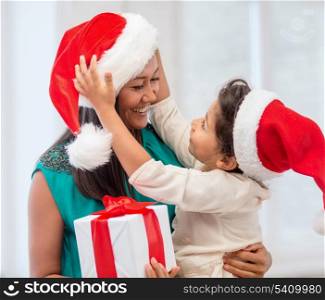 holidays, presents, christmas, x-mas concept - happy mother and child girl in santa helper hats with gift box