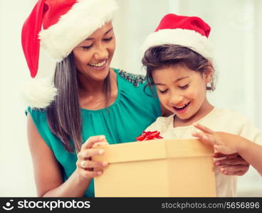 holidays, presents, christmas, x-mas concept - happy mother and child girl in santa helper hats with gift box