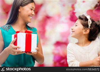 holidays, presents, family, child, christmas and x-mas concept - happy mother and child girl with gift box