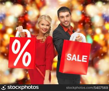 holidays, sale, christmas concept - man and woman with shopping bags