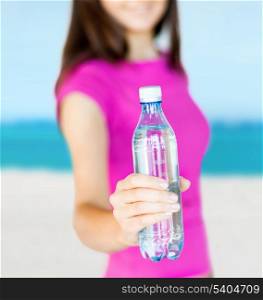 holidays, sport and diet concept - sporty woman with bottle of water