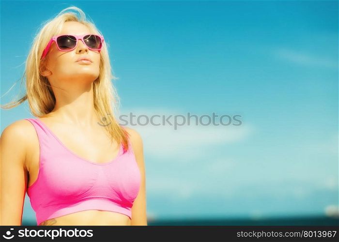 Holidays, summer active lifestyle concept. Attractive blonde fit fitness girl on beach. Young sporty woman relaxing on the sea coast.