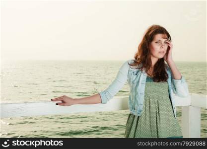 Holidays summer relaxation concept. Young woman relaxing on pier outdoor