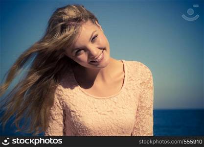 Holidays, summertime and freedom concept. Lovely blonde girl relaxing outdoor by seaside enjoying sunny windy day. Lovely blonde girl relaxing outdoor by seaside