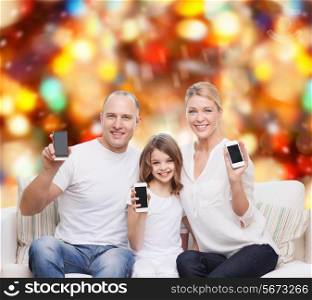 holidays, technology, advertisement and people concept - smiling family with smartphones over red lights background