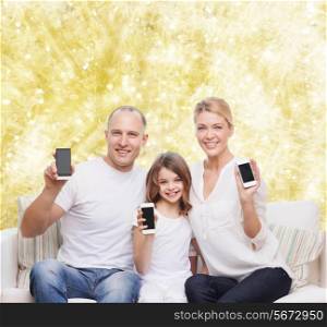 holidays, technology, advertisement and people concept - smiling family with smartphones over yellow lights background