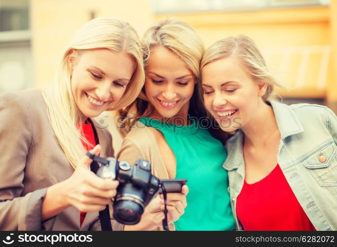 holidays, technology and tourism concept - beautiful blonde women with digital camera in the city