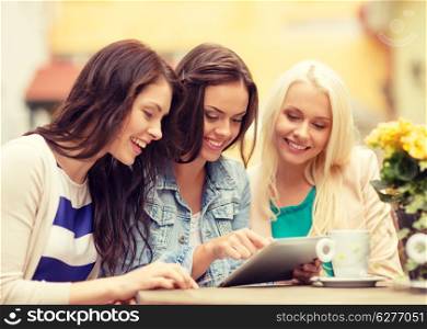 holidays, tourism, technology and internet - three beautiful girls looking at tablet pc computer in cafe outside