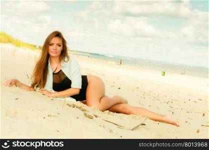 Holidays, travel freedom and beauty concept. Allurgin sexy girl on beach. Young long haired woman in full length posing on the sea coast.