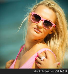 Holidays, vacation and summer fashion concept. closeup attractive blonde girl in pink sunglasses on beach outdoor