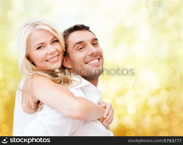 holidays, vacation, dating, love and people concept - happy couple having fun over yellow lights background