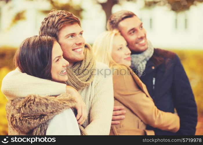 holidays, vacation, happy people concept - group of friends or couples having fun in autumn park