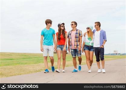 holidays, vacation, love and friendship concept - group of smiling teenagers walking outdoors
