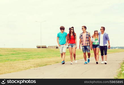 holidays, vacation, love and friendship concept - group of smiling teenagers walking outdoors