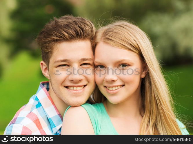 holidays, vacation, love and friendship concept - smiling couple hugging in park