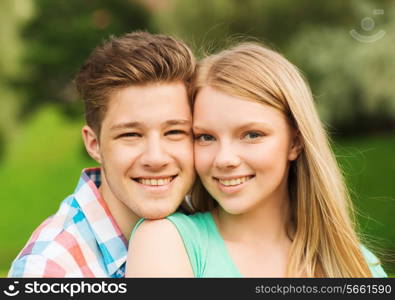 holidays, vacation, love and friendship concept - smiling couple hugging in park