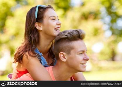 holidays, vacation, love and people concept - happy smiling teenage couple having fun at summer park
