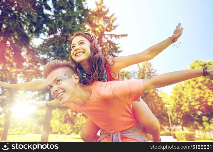 holidays, vacation, love and people concept - happy smiling teenage couple having fun at summer park. happy teenage couple having fun at summer park