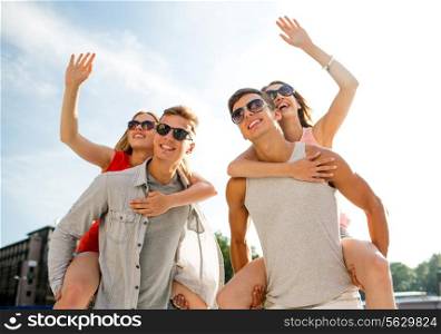 holidays, vacation, love, gesture and friendship concept - smiling couple having fun and waving hands in city