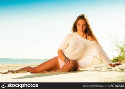Holidays, vacation tourism and beauty concept. Full length of attractive girl long haired on sandy beach. Tanned woman in summer clothing relaxing on the sea shore, blue sky