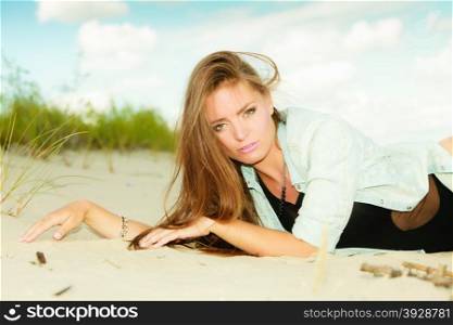 Holidays, vacation travel and freedom concept. Adorable long haired girl laying on sandy beach outdoor
